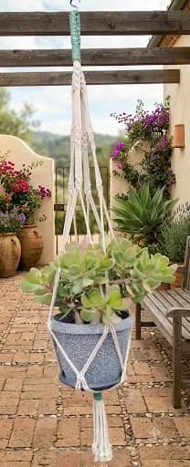 Porta macetas colgante de macramé blanco en patio